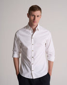 Man wearing a white dress shirt against a plain background. Perfect for a wedding.