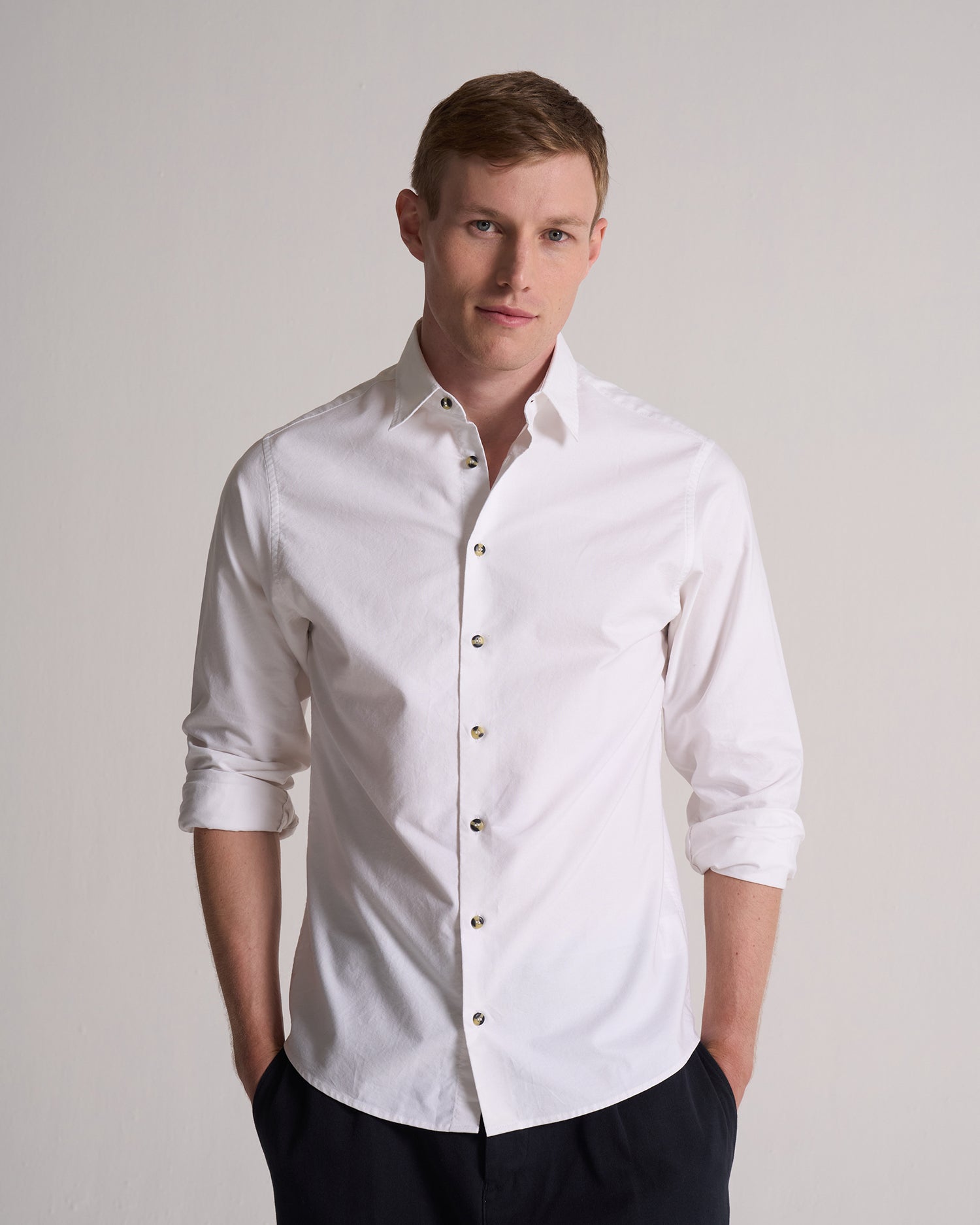 Man wearing a white dress shirt against a plain background. Perfect for a wedding.