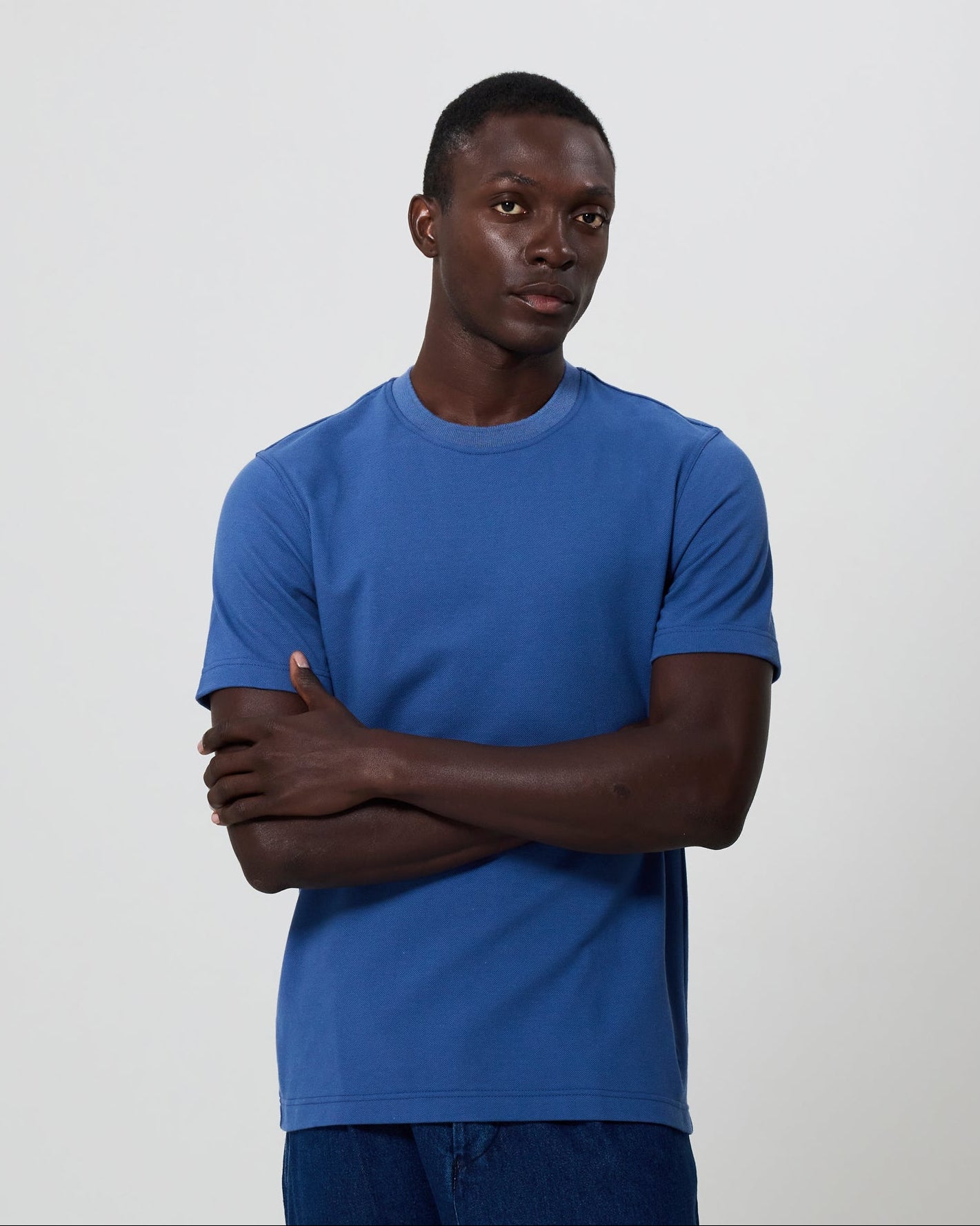Man wearing a blue t-shirt and denim against a plain background. All clothing from Fields