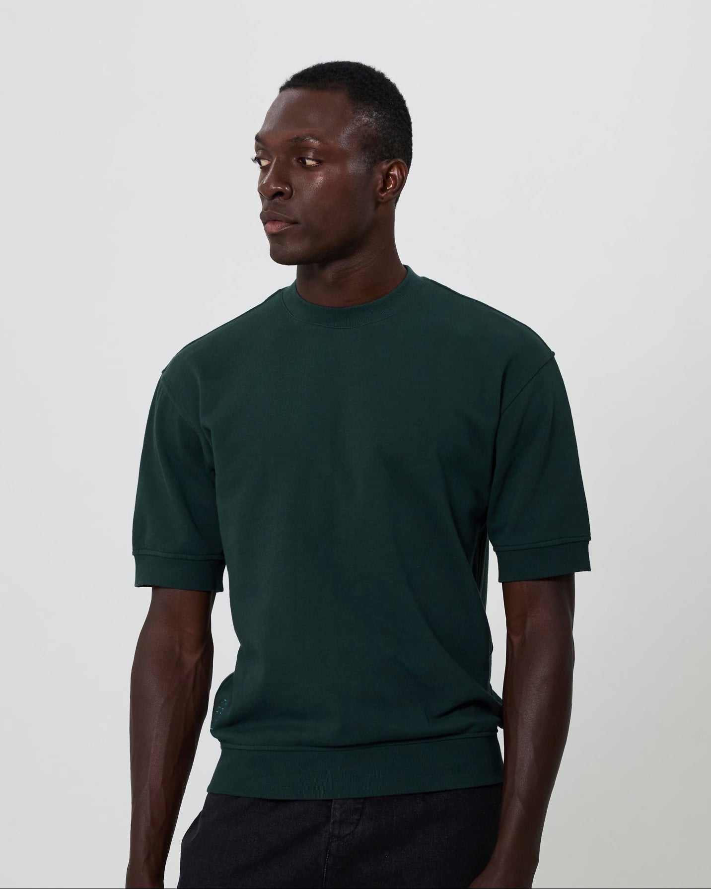 Man wearing a dark green box sweater against a plain background. From Fields.